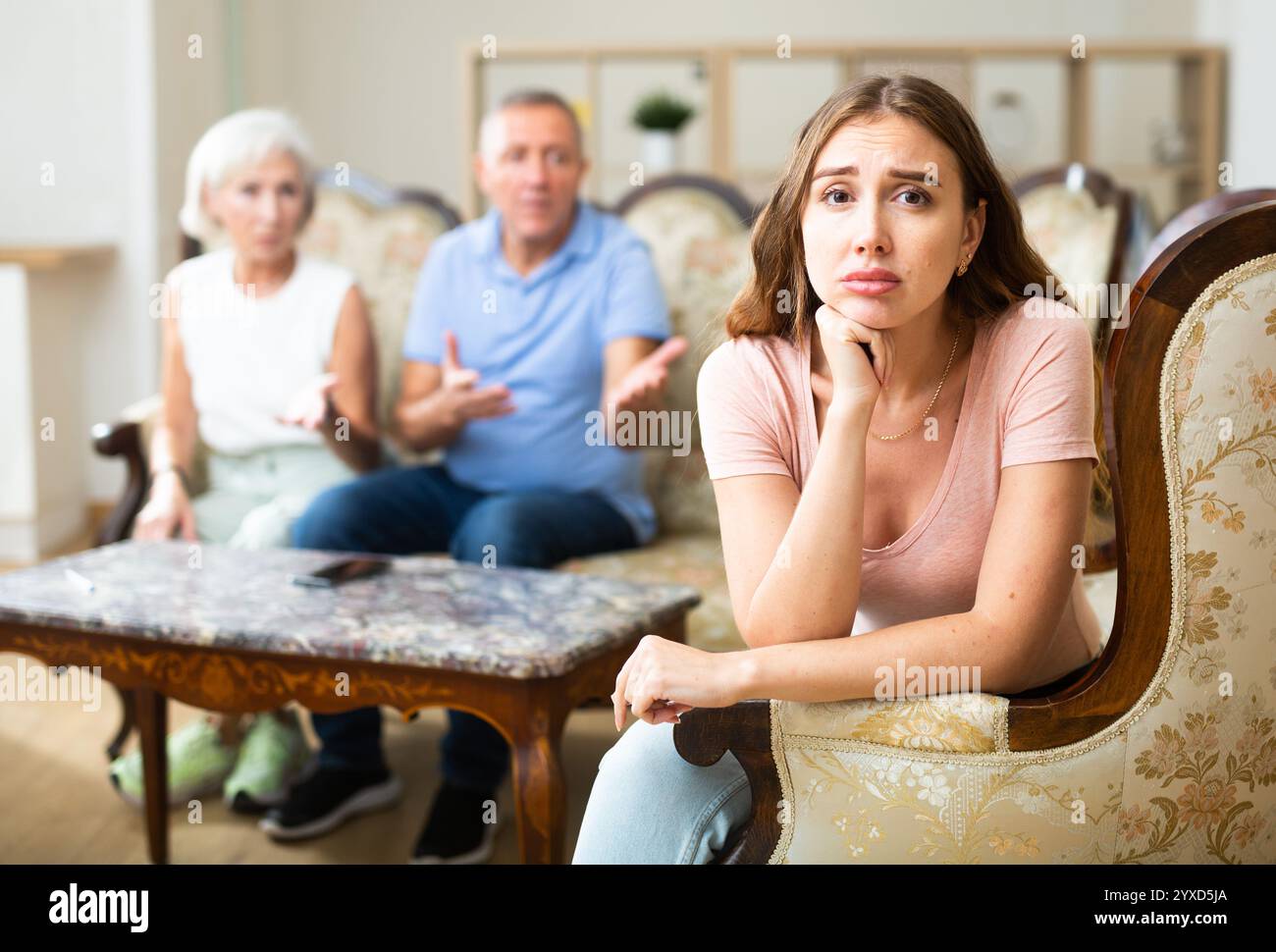 Sad portrait girl sitting on the sofa Stock Photo - Alamy