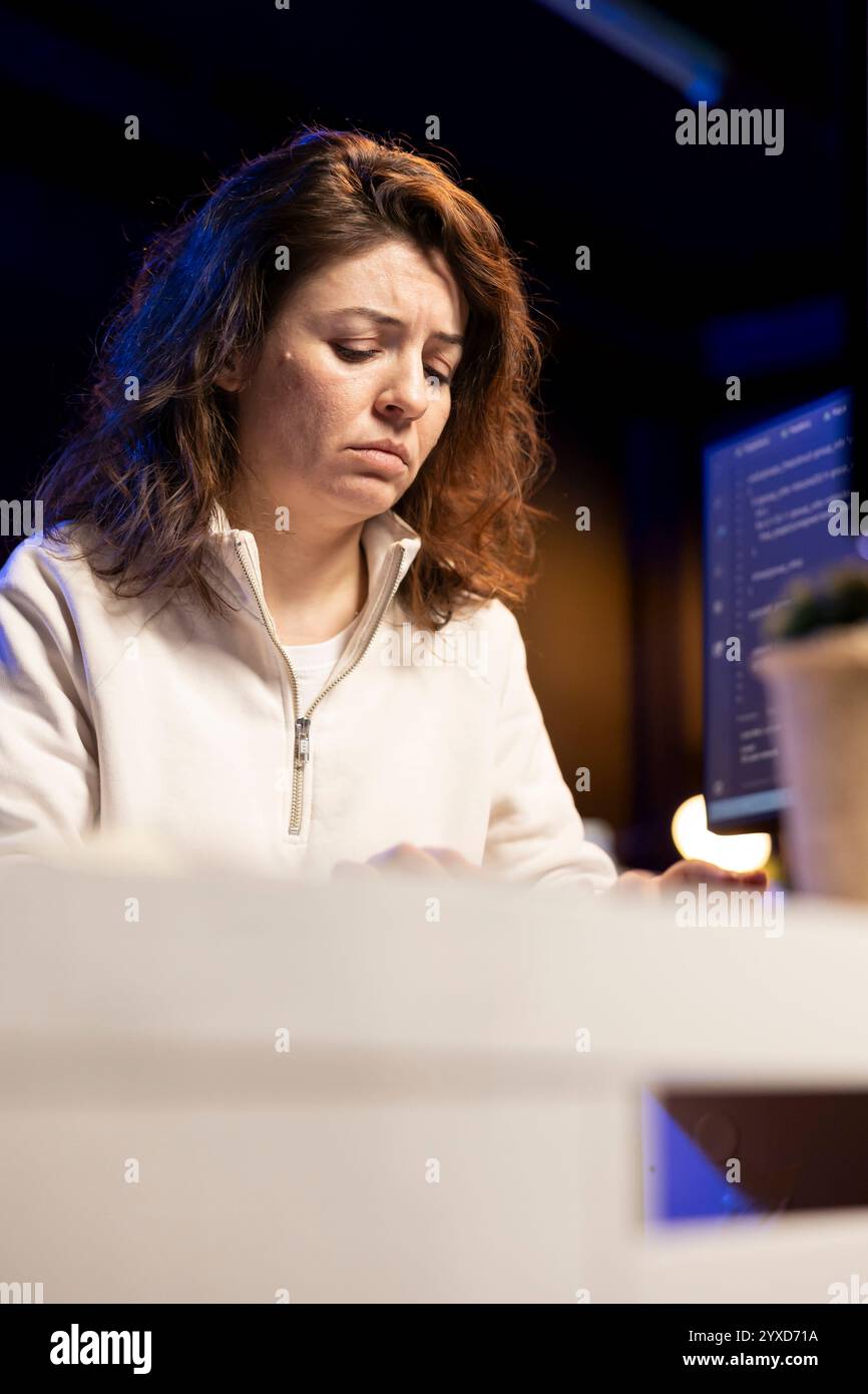 Sad system administrator pouting in frustration while doing software quality assurance, finding errors. Upset IT staff member inspecting coding on PC and seeing many issues Stock Photo