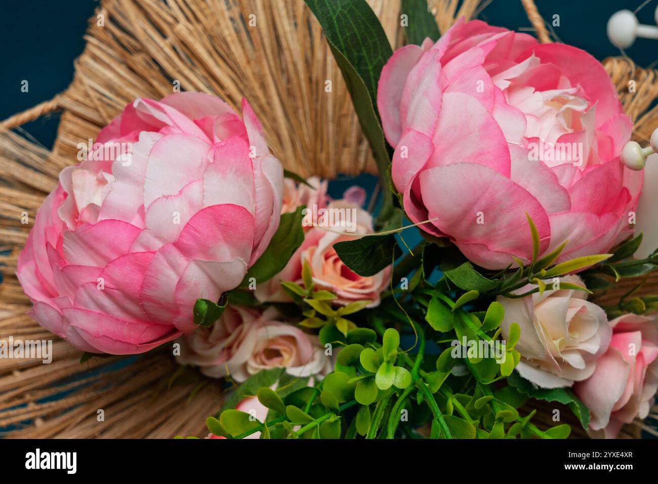 Vibrant pink peonies and soft roses are arranged artistically with lush ...