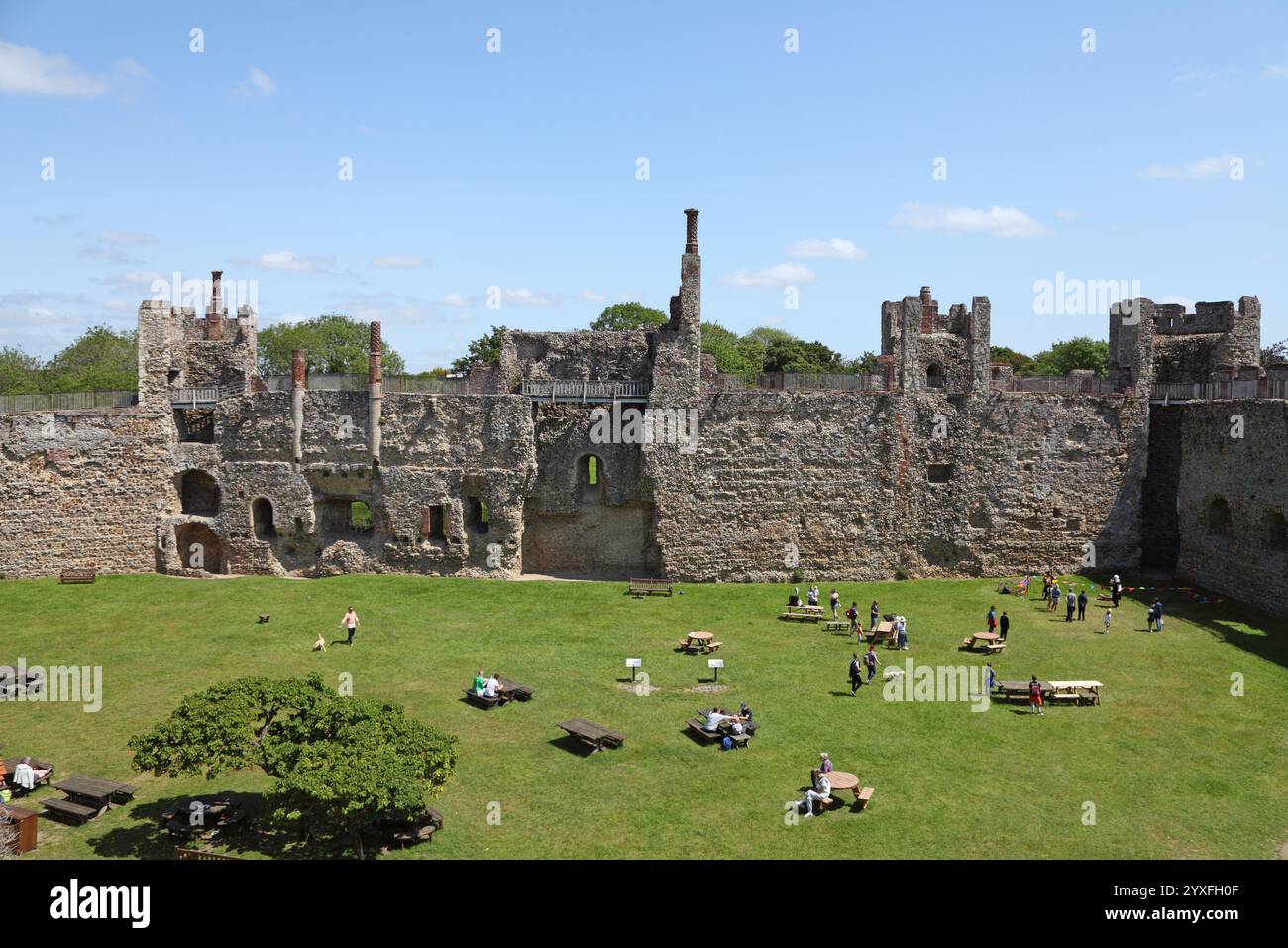 Tourists relaxing on a summer day in the gounds of the medieval ...