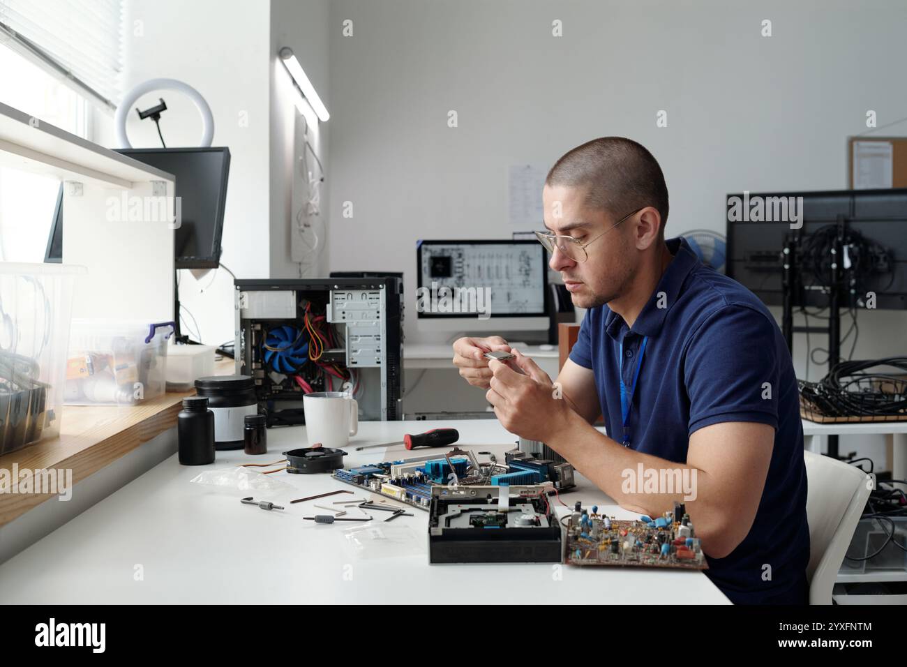 Man Fixing Electronic Device at Workbench Desk Stock Photo - Alamy