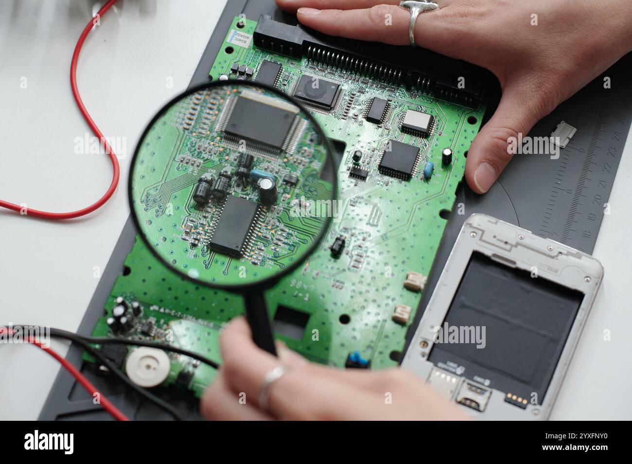 Examining Electronic Circuit Board with Magnifying Glass Stock Photo ...