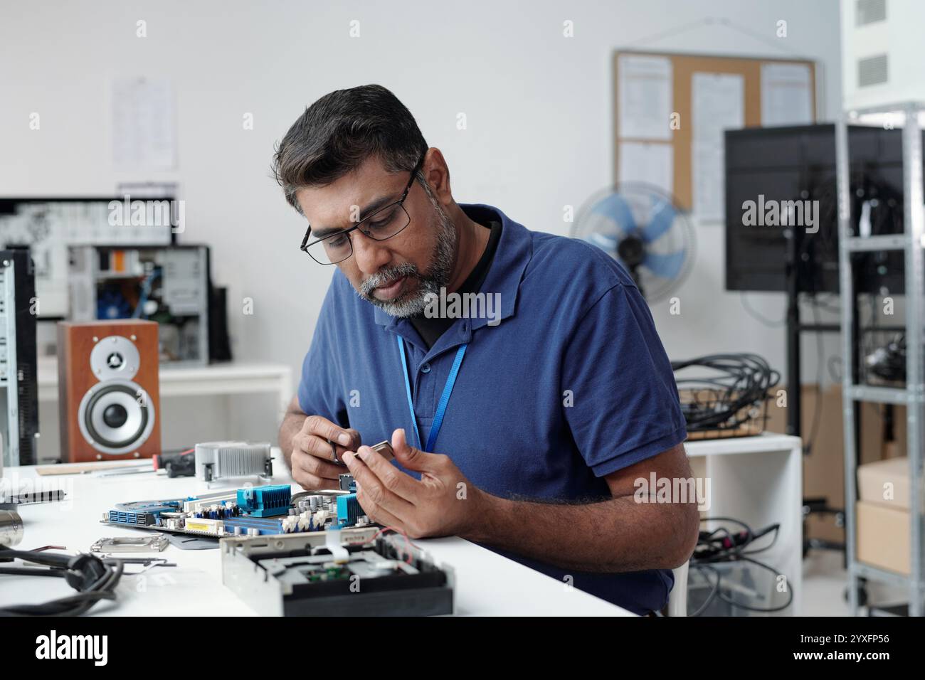 Working on Electronic Circuit Board in Tech Lab Stock Photo
