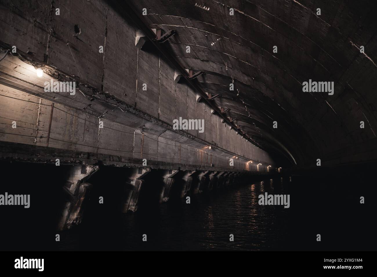 Dark industrial concrete tunnel perspective, part of abandoned underground submarine base from USSR period. Balaklava, Crimea Stock Photo