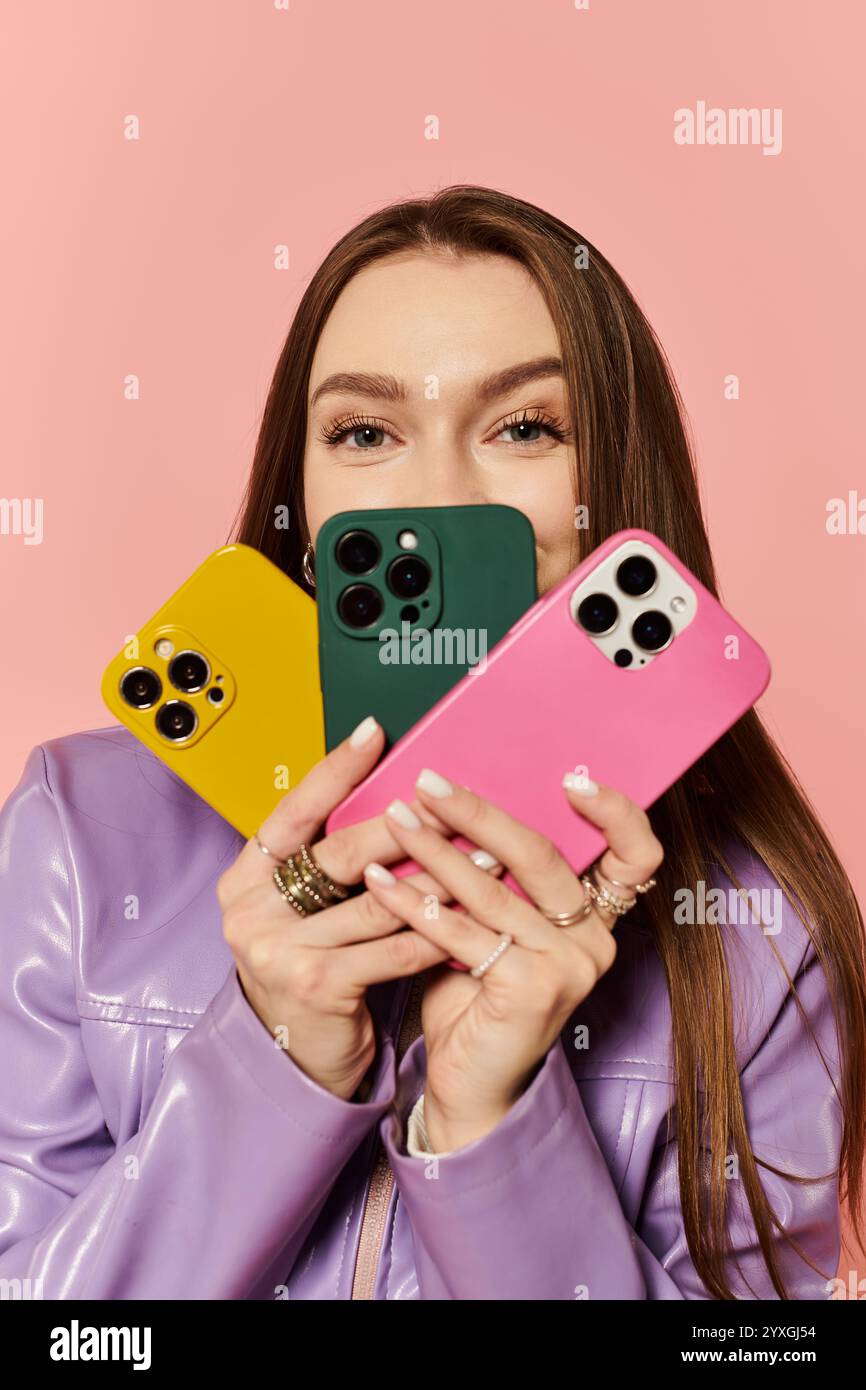 Beautiful woman showcases trendy phone cases while smiling with vibrant energy and style. Stock Photo