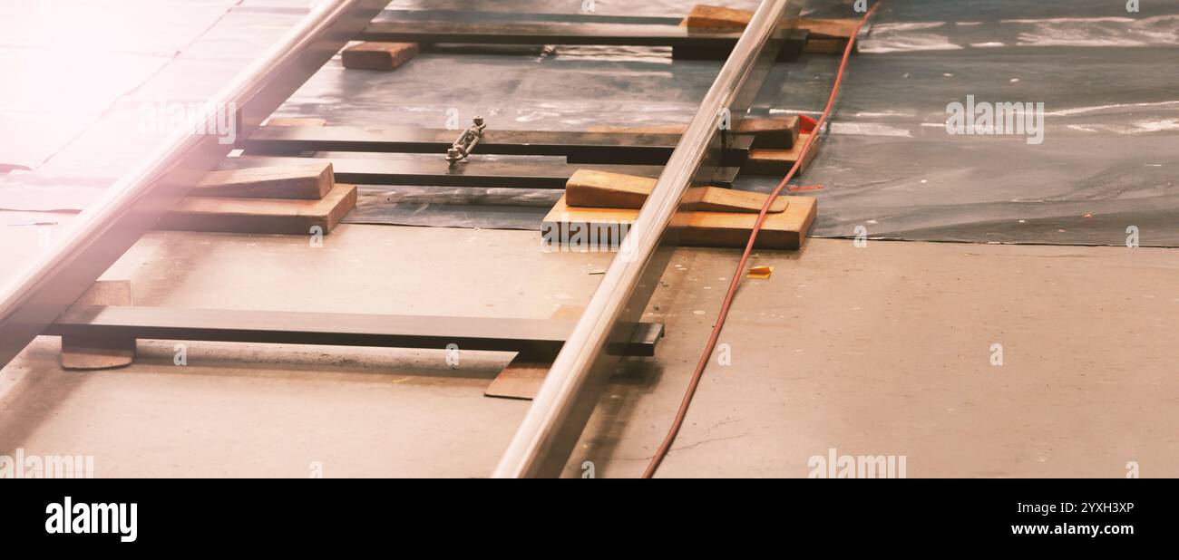Camera trolley or camera dolly cart rails for filmmaking on studio shooting set. Pro videographer dolly rail track for filming movie mounted on studio Stock Photo