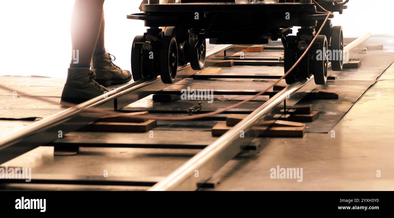 Camera trolley or camera dolly cart rails for filmmaking on studio shooting set. Pro videographer dolly rail track for filming movie mounted on studio Stock Photo