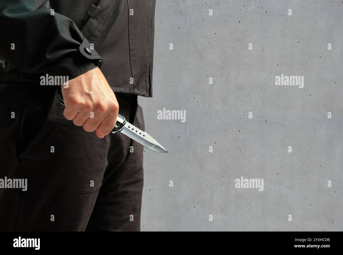 Criminal holding a knife closeup view, grey background, armed attack ...