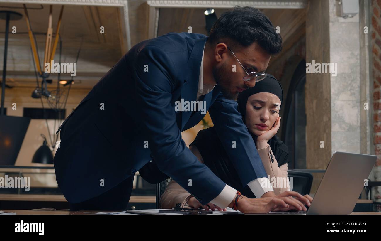 Muslim woman hijab female businesswoman student work laptop at office Arabian man male businessman teacher mentor help employee support approve good Stock Photo