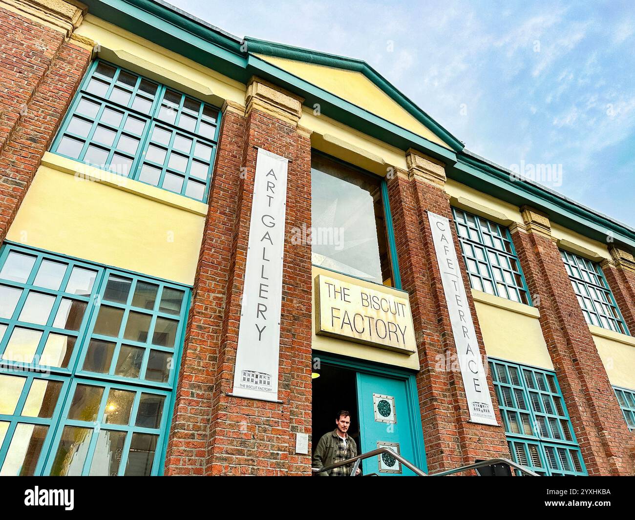 Exterior view of the Biscuit Factory art gallery and cultural space with entrance banners and a clear sky newcastle upon tyne uk - Smartphone Captured Stock Image