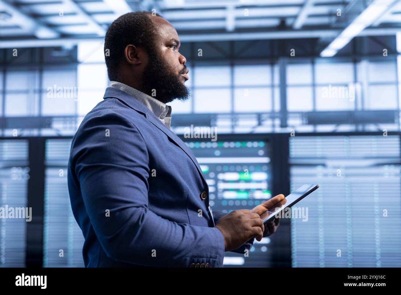 Supervising manager in data center implements backup solutions to protect against data loss using tablet, ensuring efficiency. High tech establishment IT expert resolving technical issues using device Stock Photo