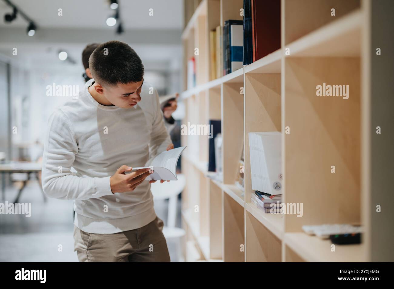High school student browsing books in a modern library setting Stock ...