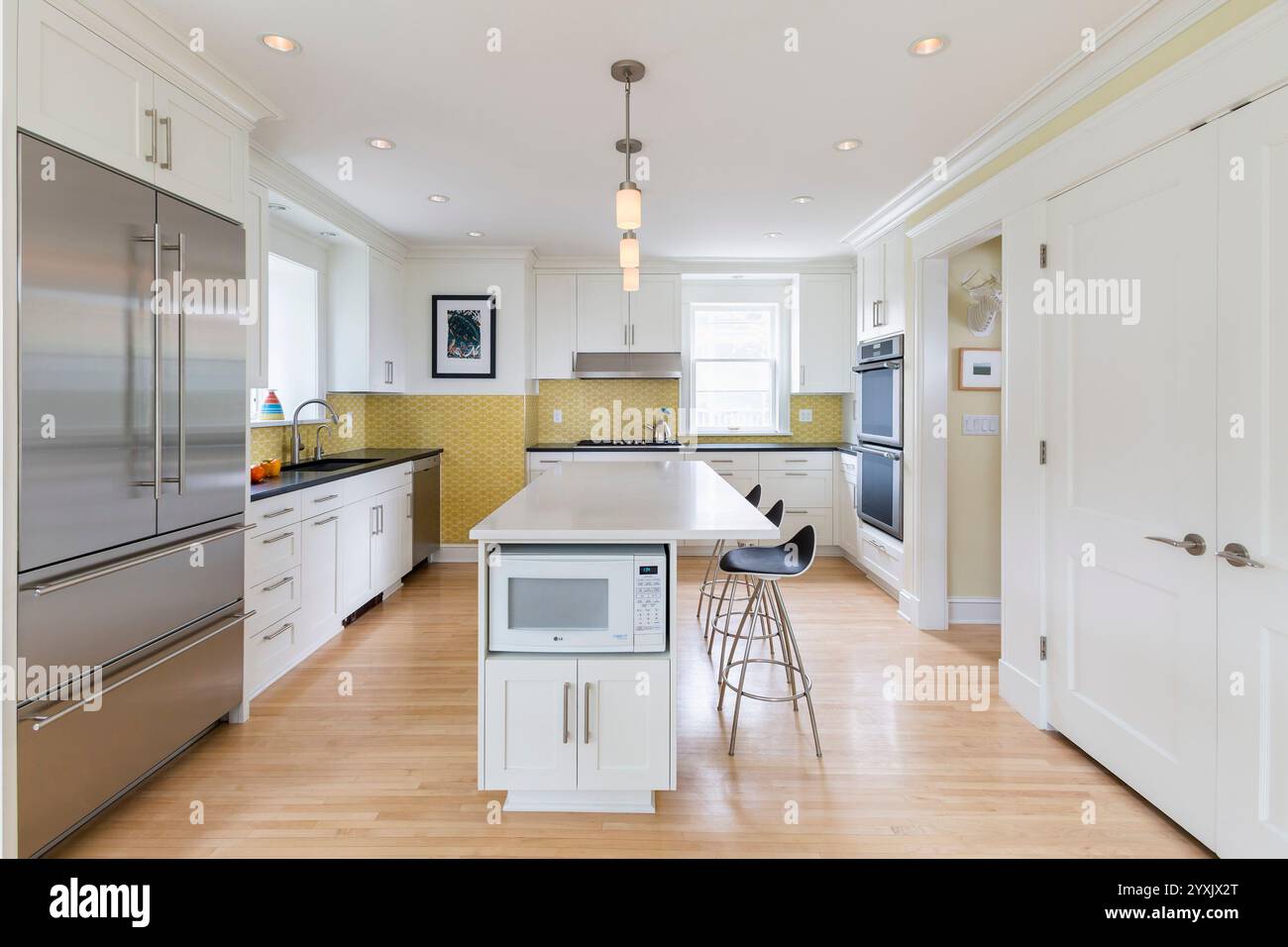 White kitchen with island and yellow backsplash tile Stock Photo - Alamy