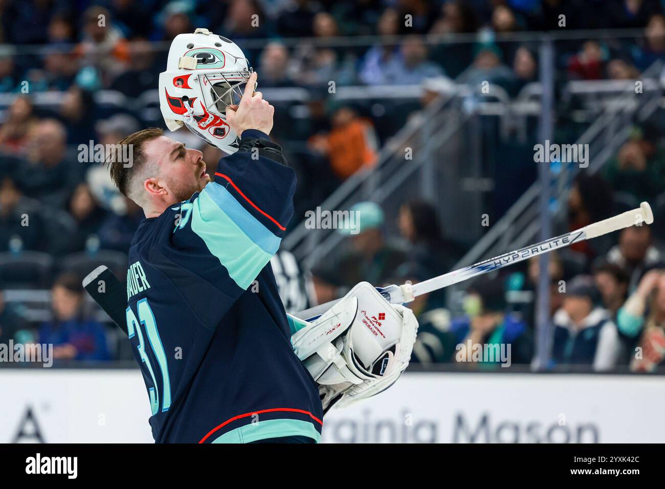 Seattle Kraken goaltender Philipp Grubauer puts on his helmet during an