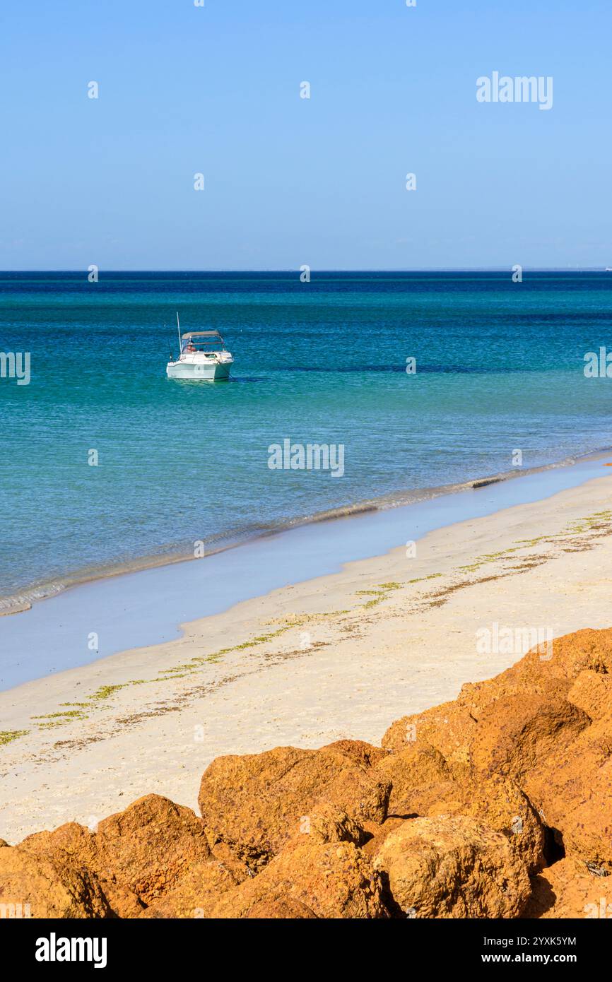 Lone boat anchored off Busselton Beach in Broadwater, City of Busselton, Western Australia Stock Photo