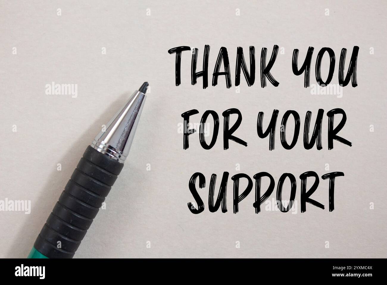 Thank you for your support message written on white paper with a pen ...