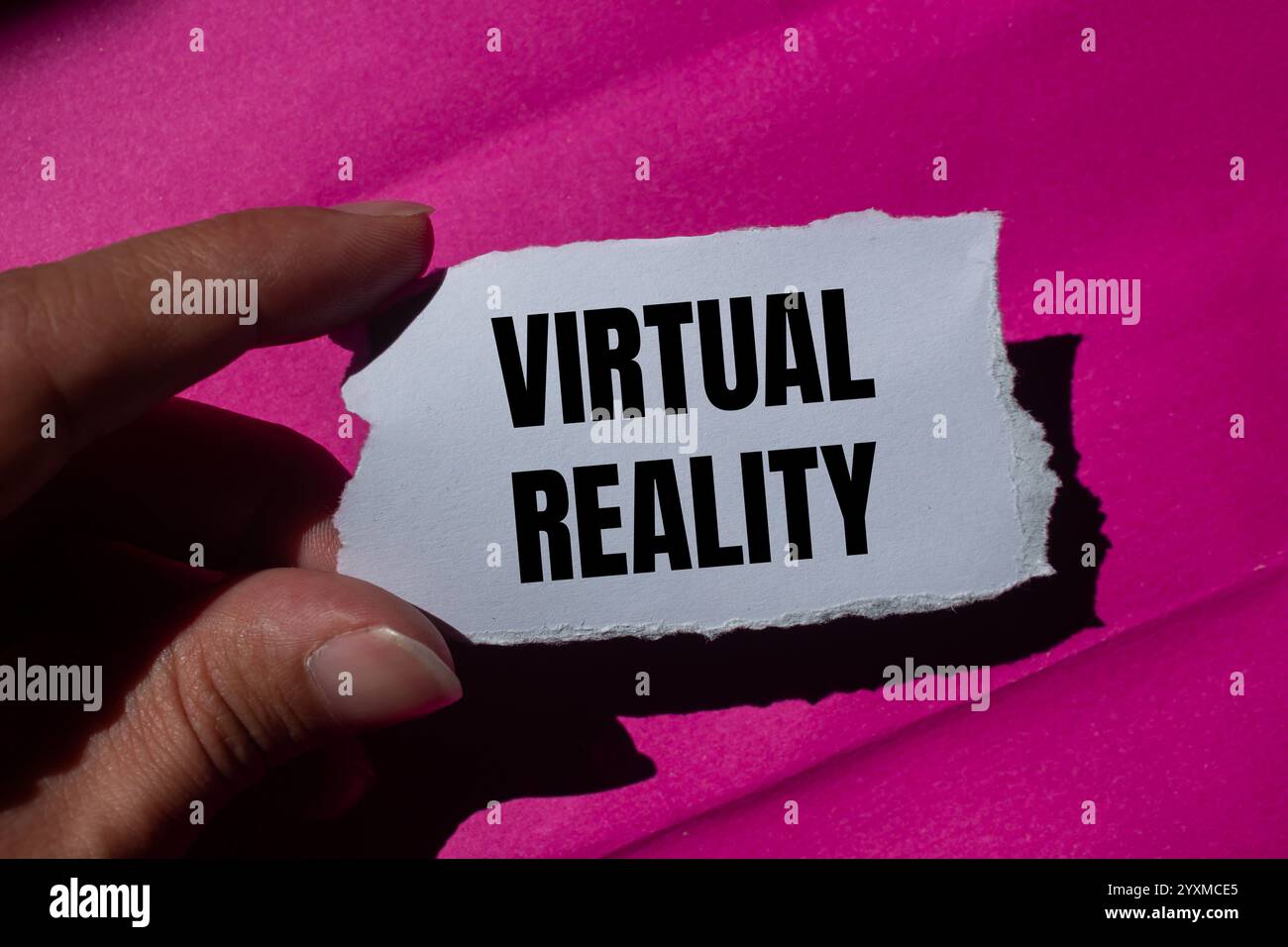 Reality On Paper Virtual reality message written on ripped torn paper piece with a pink ...