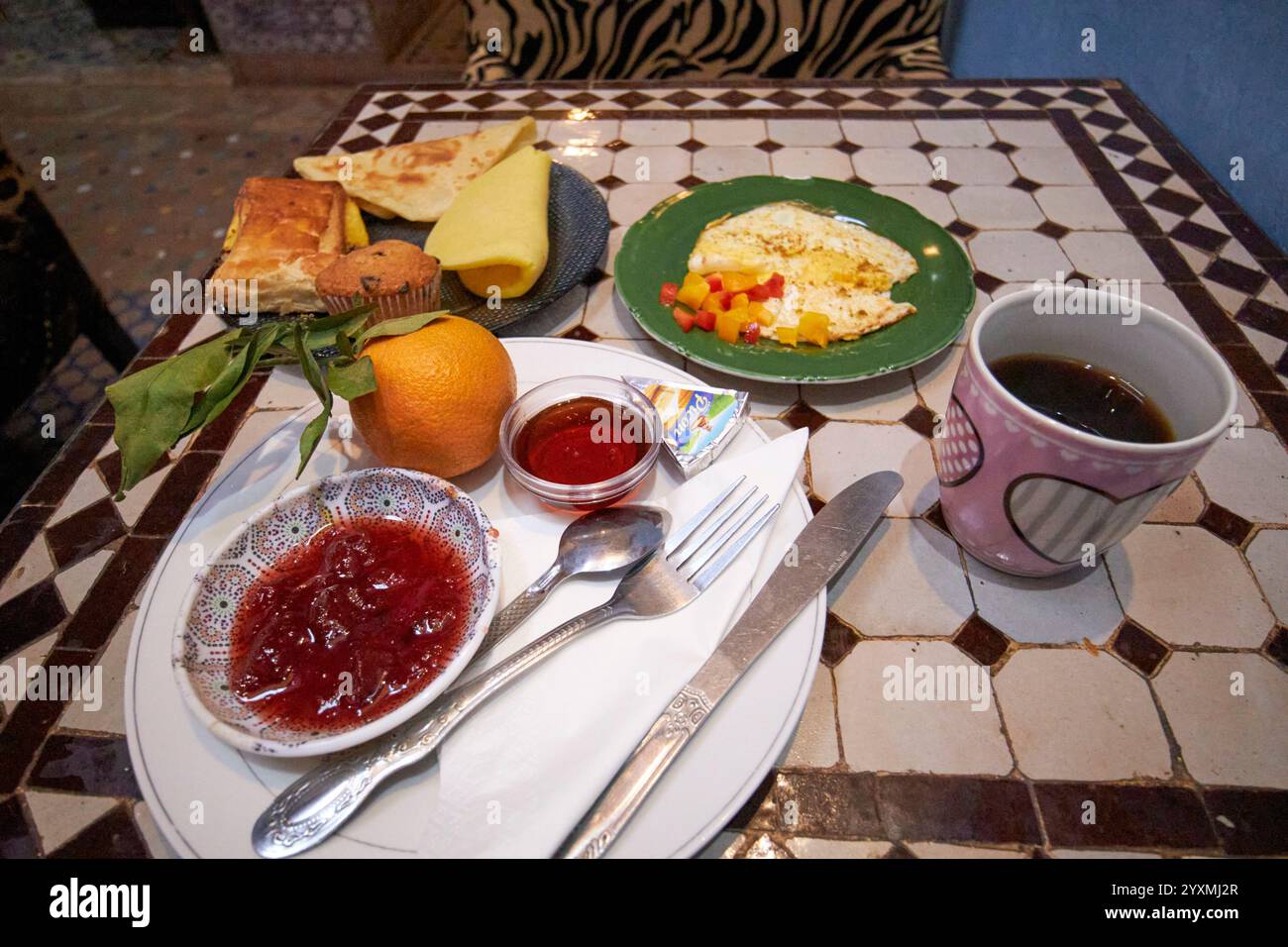 moroccan breakfast of eggs, pancakes, pastries and fresh fruit in a riad marrakesh, morocco Stock Photo