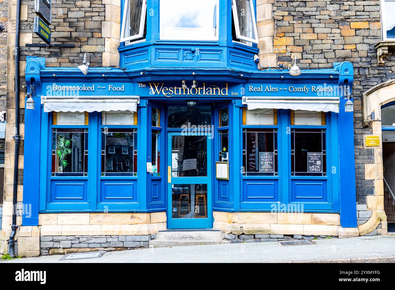 Exterior view of the blue Westmorland Inn, Bowness-on-Windermere, Cumbria, Lake District, England, a stone building Stock Photo