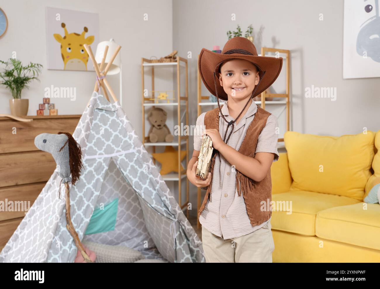 Cute little cowboy with book at home Stock Photo