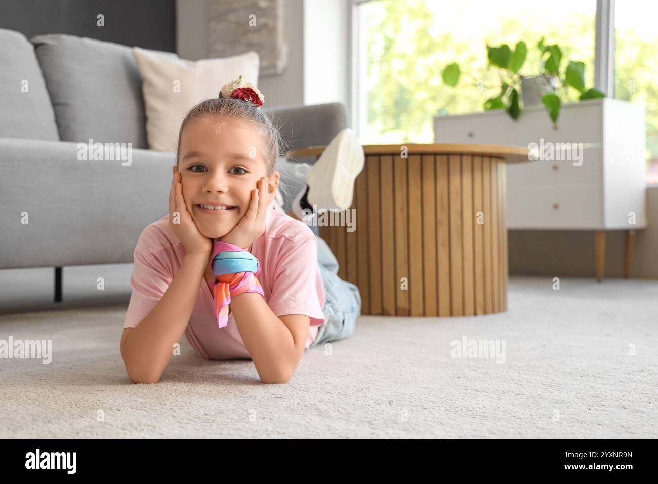 Little girl lying on carpet at home Stock Photo - Alamy