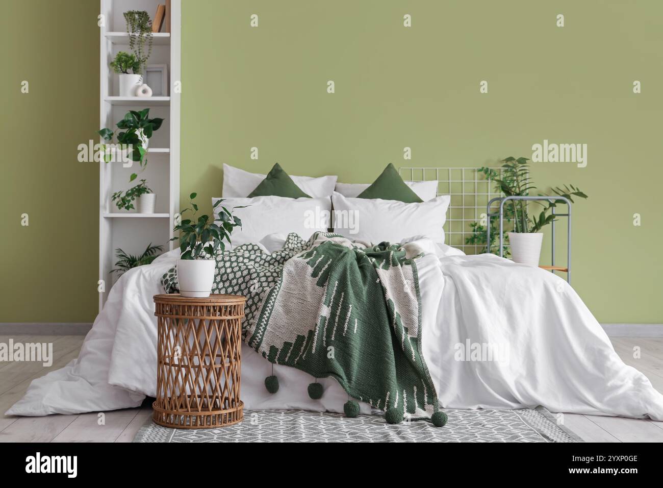 Interior of bedroom with table, shelf unit and green plants Stock Photo ...