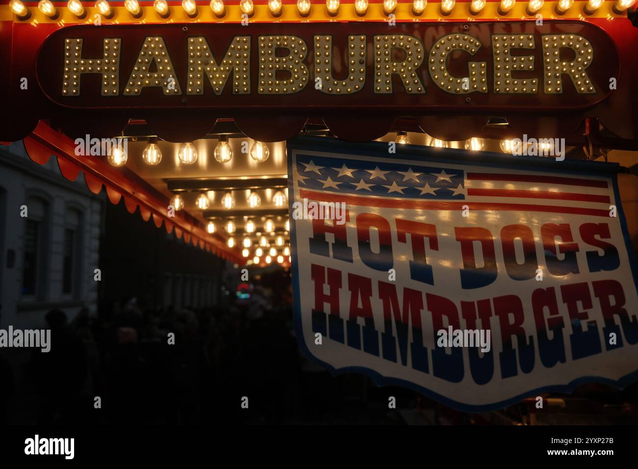 Hamburger and hot dogs sign hanging over a restaurant. The sign is lit up and has a patriotic theme Stock Photo