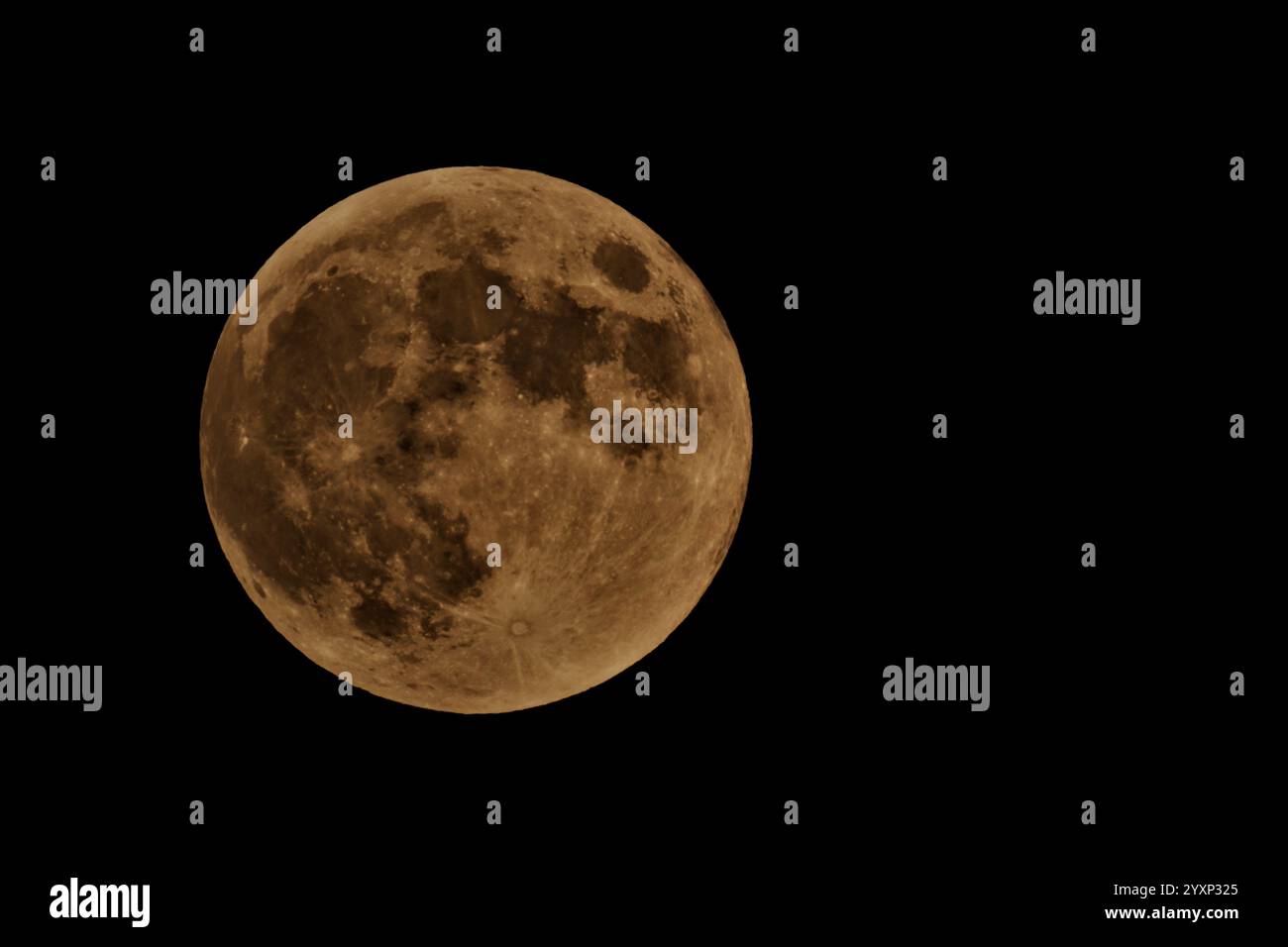 A large, round moon is in the sky. The moon is surrounded by a dark ...