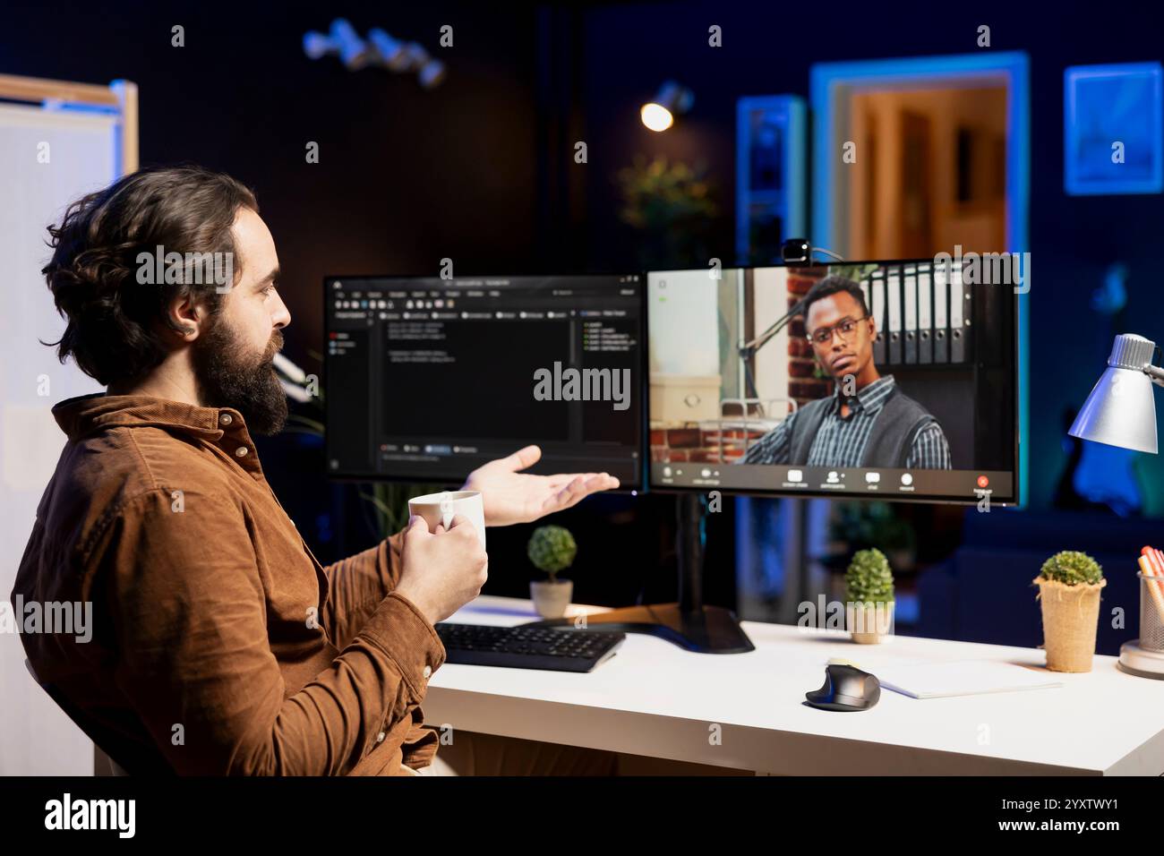 IT developer working from home in remote videocall with BIPOC coworker, testing programs and systems. Programmer checking code with colleague in internet videoconference meeting Stock Photo