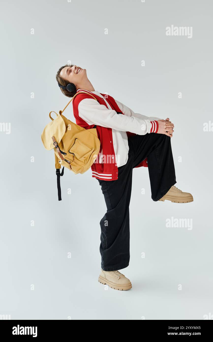 Young man dressed in a bomber jacket and backpack confidently poses in ...