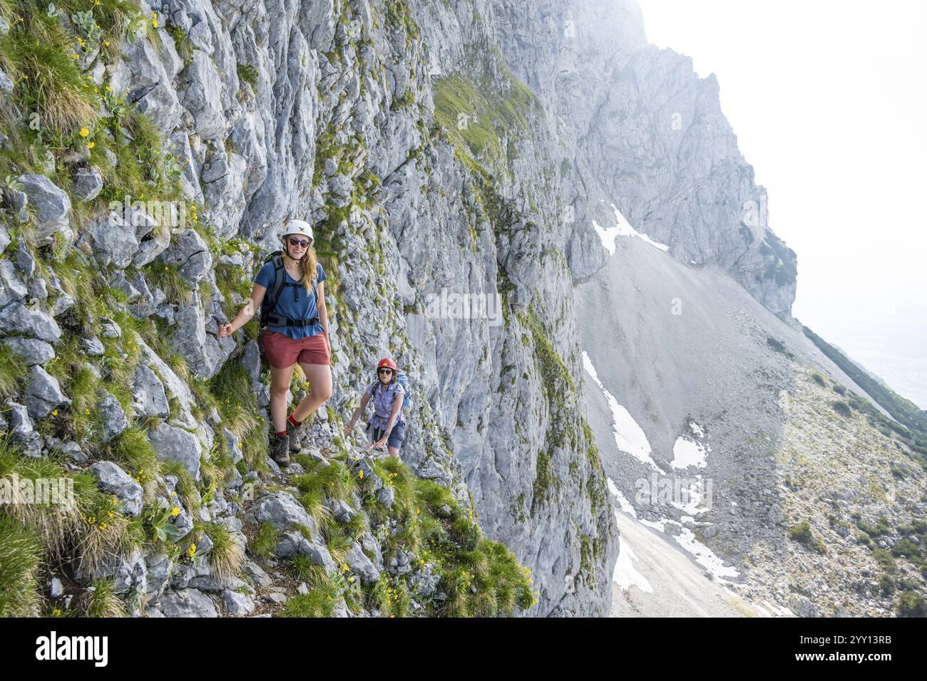 Two mountaineers with helmets climbing on a rock face, ascent to the Ackerlspitze, Wilder Kaiser, Kaiser Mountains, Tyrol, Austria, Europe Stock Photo