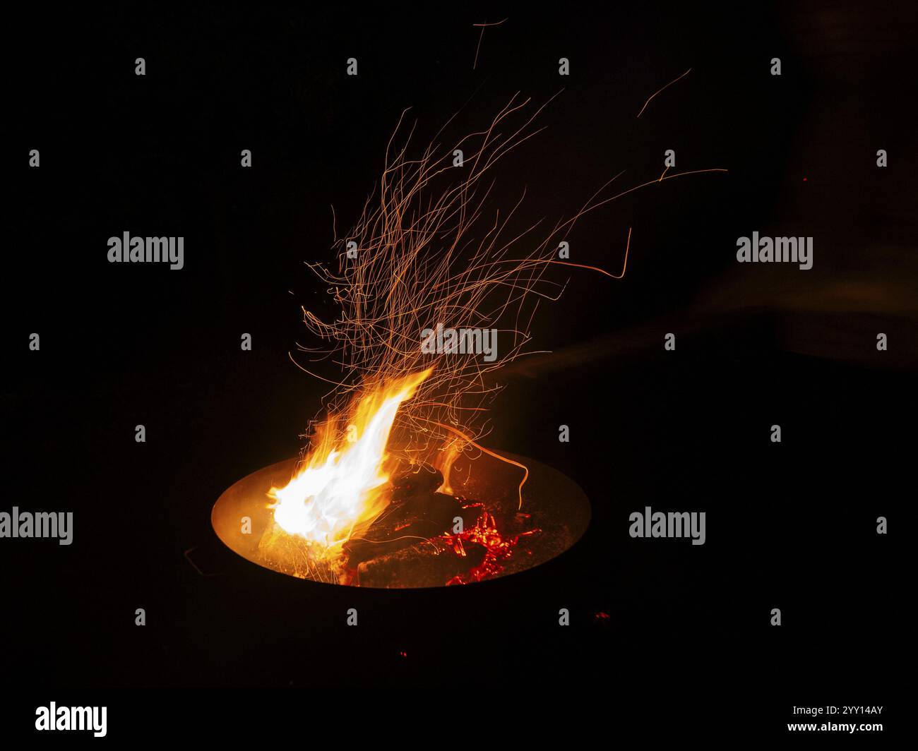 Garden Barbecue Pan, filled with burning wood, creating flames and sparks against the nighttime surroundings, North Hesse, Germany, Europe Stock Photo