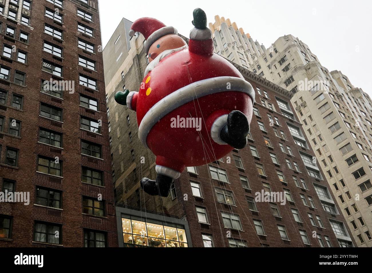 FILE Handlers guide a Santa Claus balloon down Sixth Avenue during