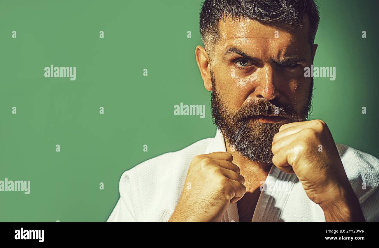 Closeup portrait of serious karate man in fighting position. Male karate instructor with clenched fists ready for karate training. Karate fighter Stock Photo