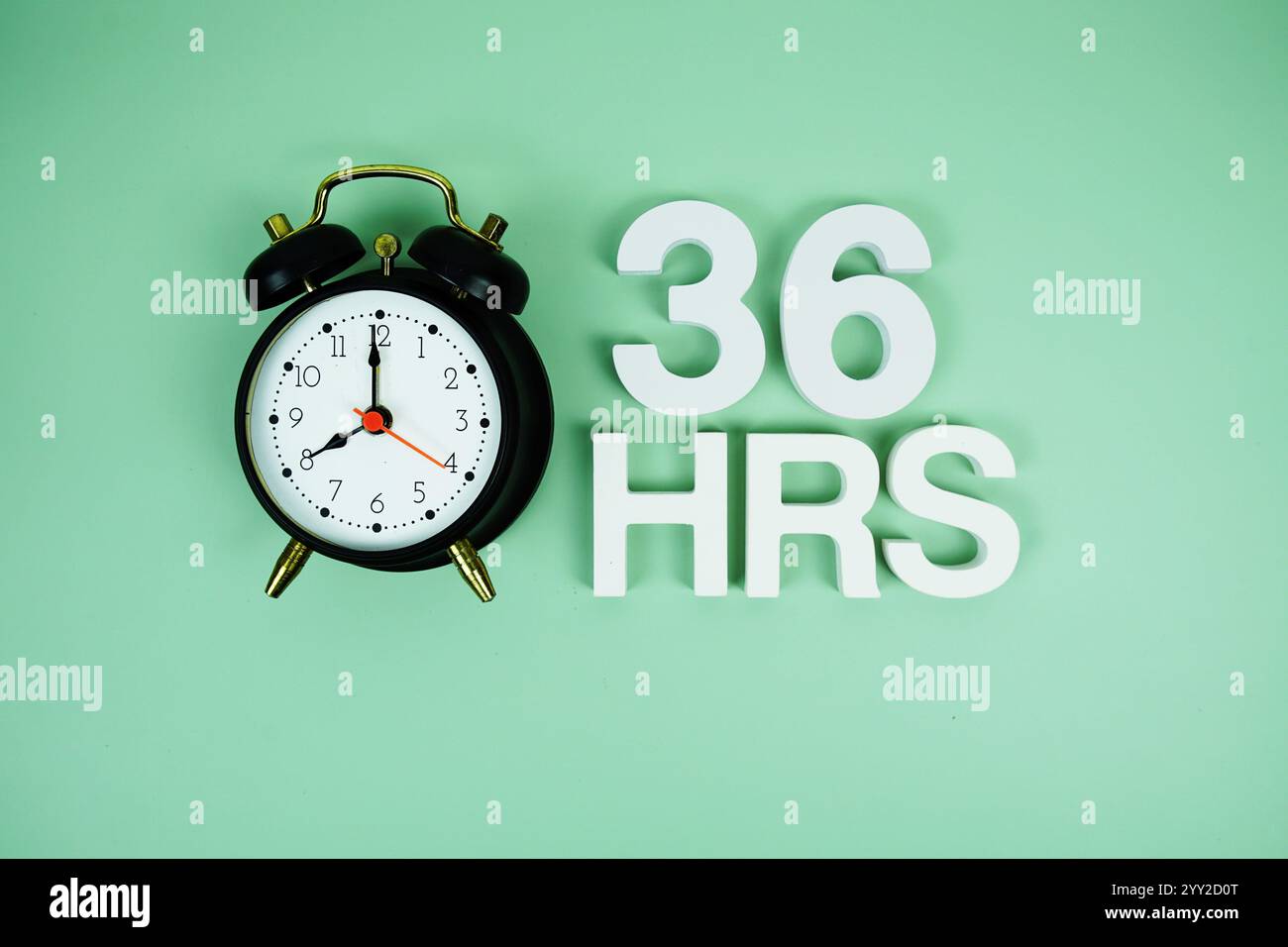 36 Hrs alphabet letters and alarm clock top view on green background ...