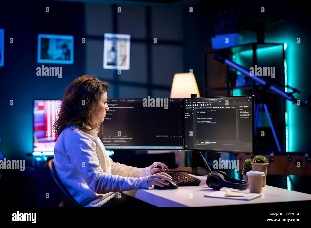 Developer in neon lit apartment implement security measures, protecting company systems and data. System administrator working from home, testing and debugging Javascript code Stock Photo