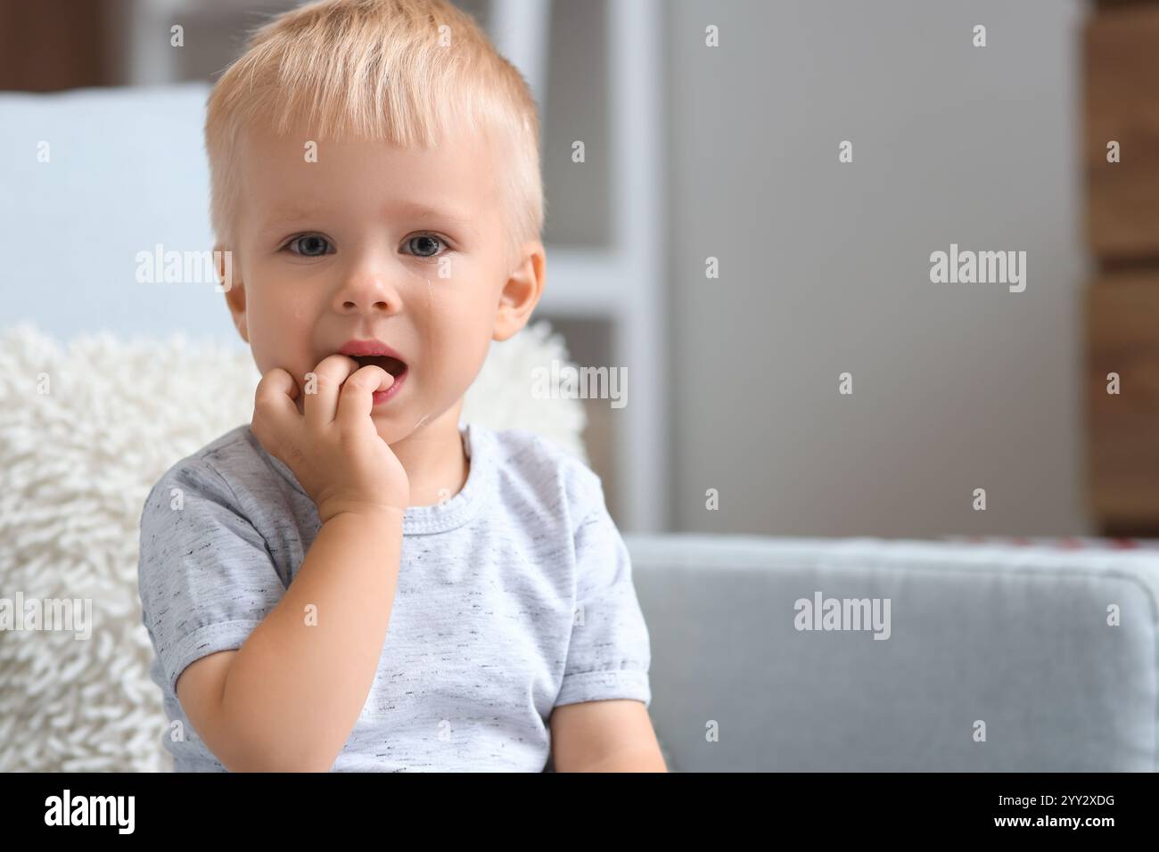 Cute baby boy crying at home, closeup Stock Photo