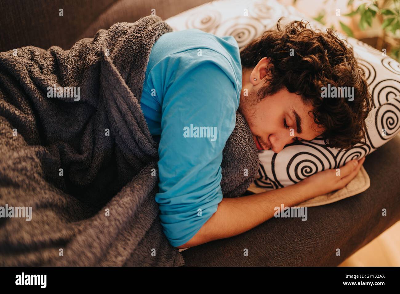 Young man sleeping peacefully on a comfortable couch at home Stock Photo