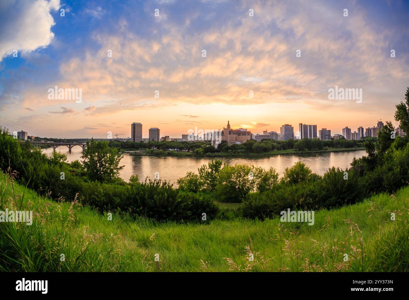 A city skyline is visible in the distance with a river running through it. The sky is a mix of blue and orange hues, creating a serene and peaceful at Stock Photo