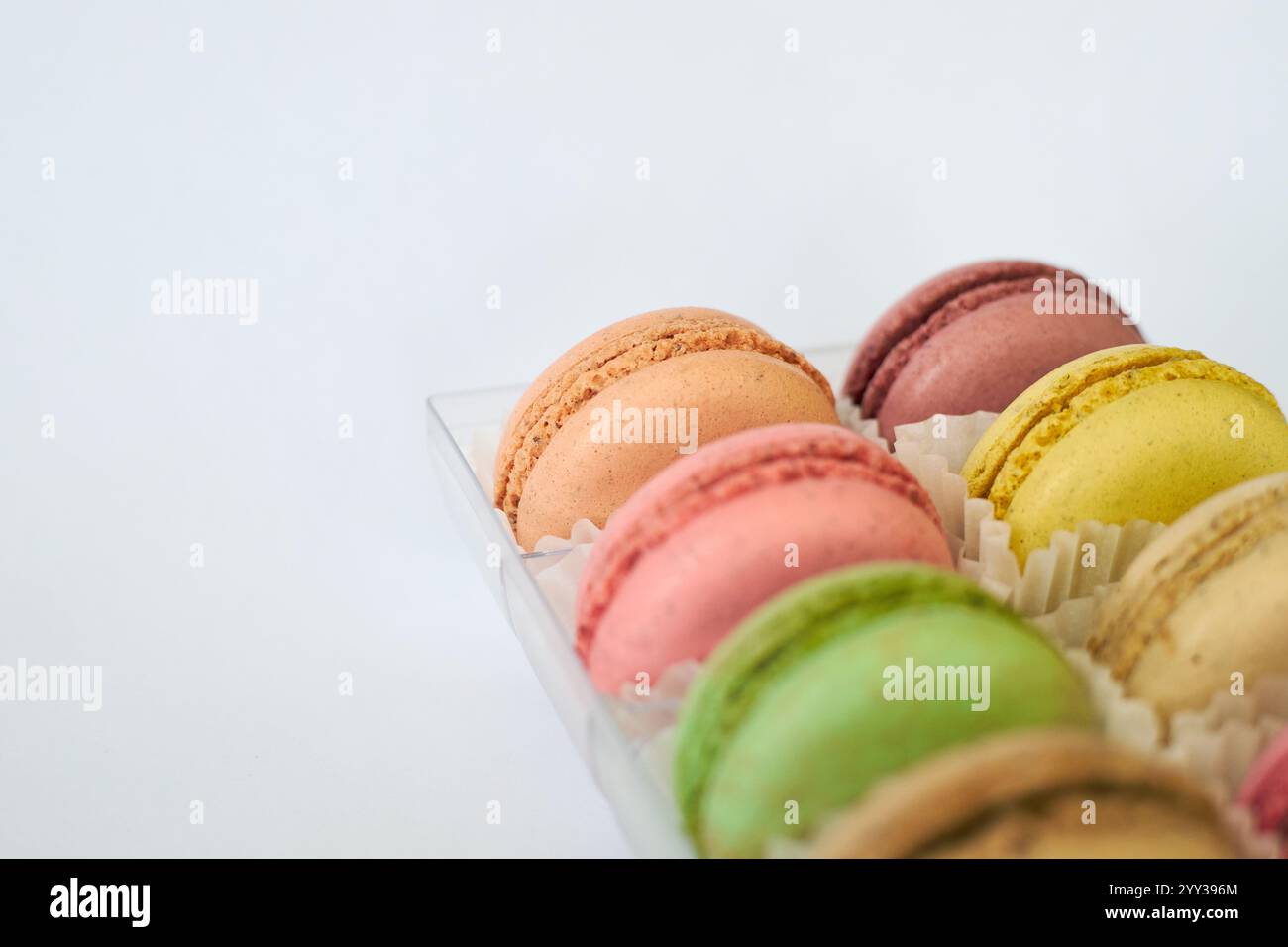 French Macarons with white paperpan in plastic transparent packaging box on gray background, colorful cakes with various flavors. appetizing dessert, Stock Photo