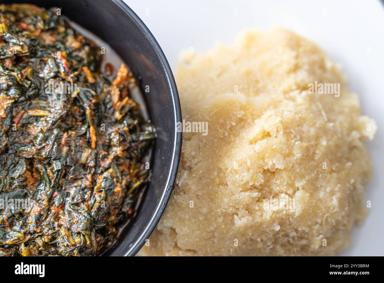 Nigerian Spicy vegetable soup and Eba fufu ready to eat Stock Photo - Alamy