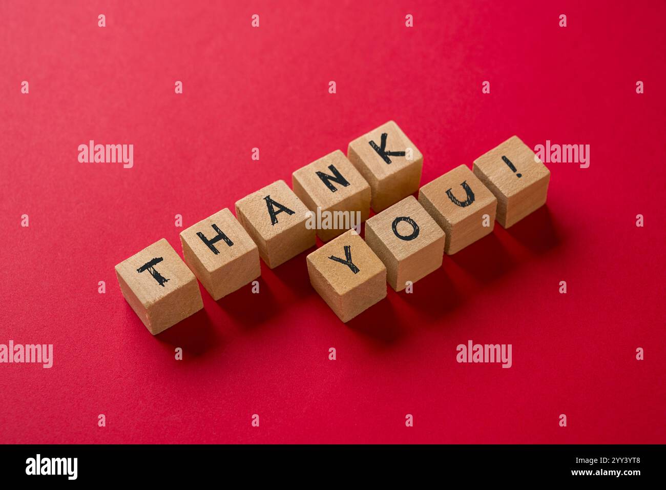 Thank you is written on wooden blocks standing on a red background Stock Photo