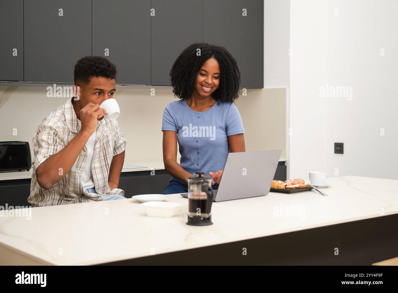 A young Black couple enjoys a relaxed morning together in their modern ...