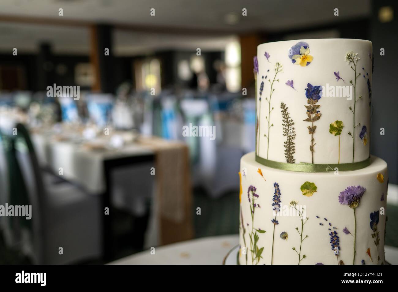wedding cake on table with room blurred in background Stock Photo