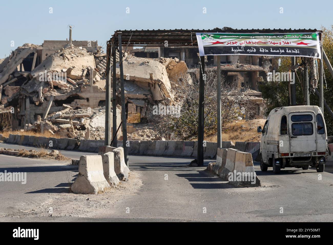 A car passes by destroyed buildings in the neighborhood of Jobar in ...