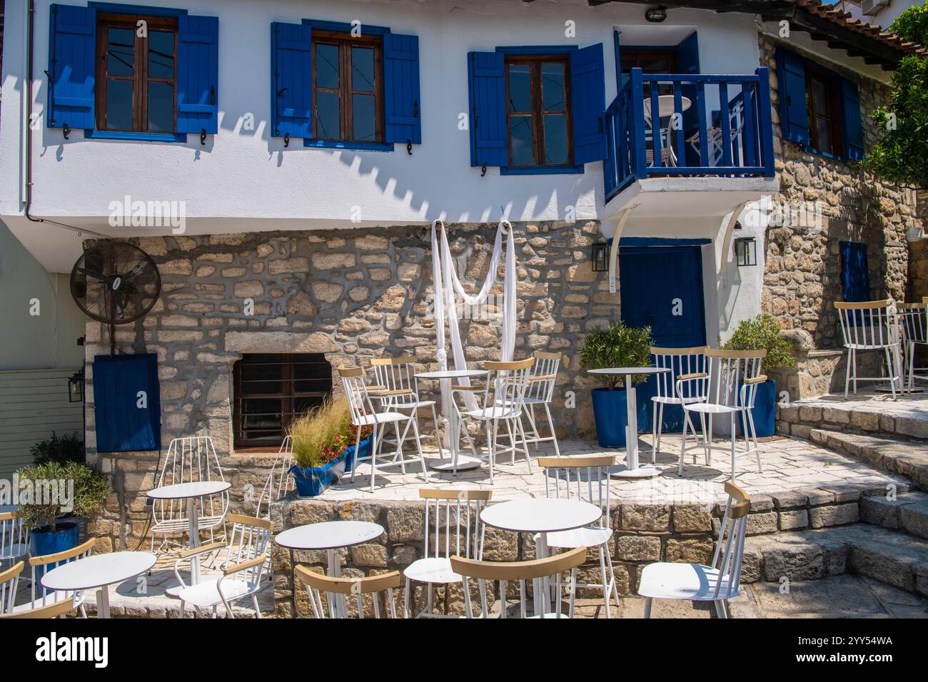 Restaurants and taverns next to sea in historical town. Situated on top of a hill the village of Afitos or Athitos, features stone houses Stock Photo