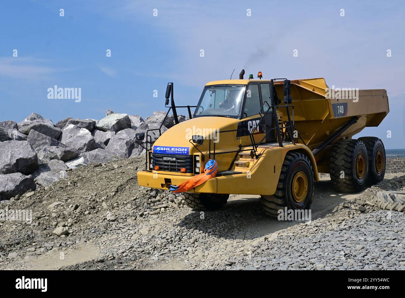 dump trucks transporting rocks for a water brake Stock Photo - Alamy