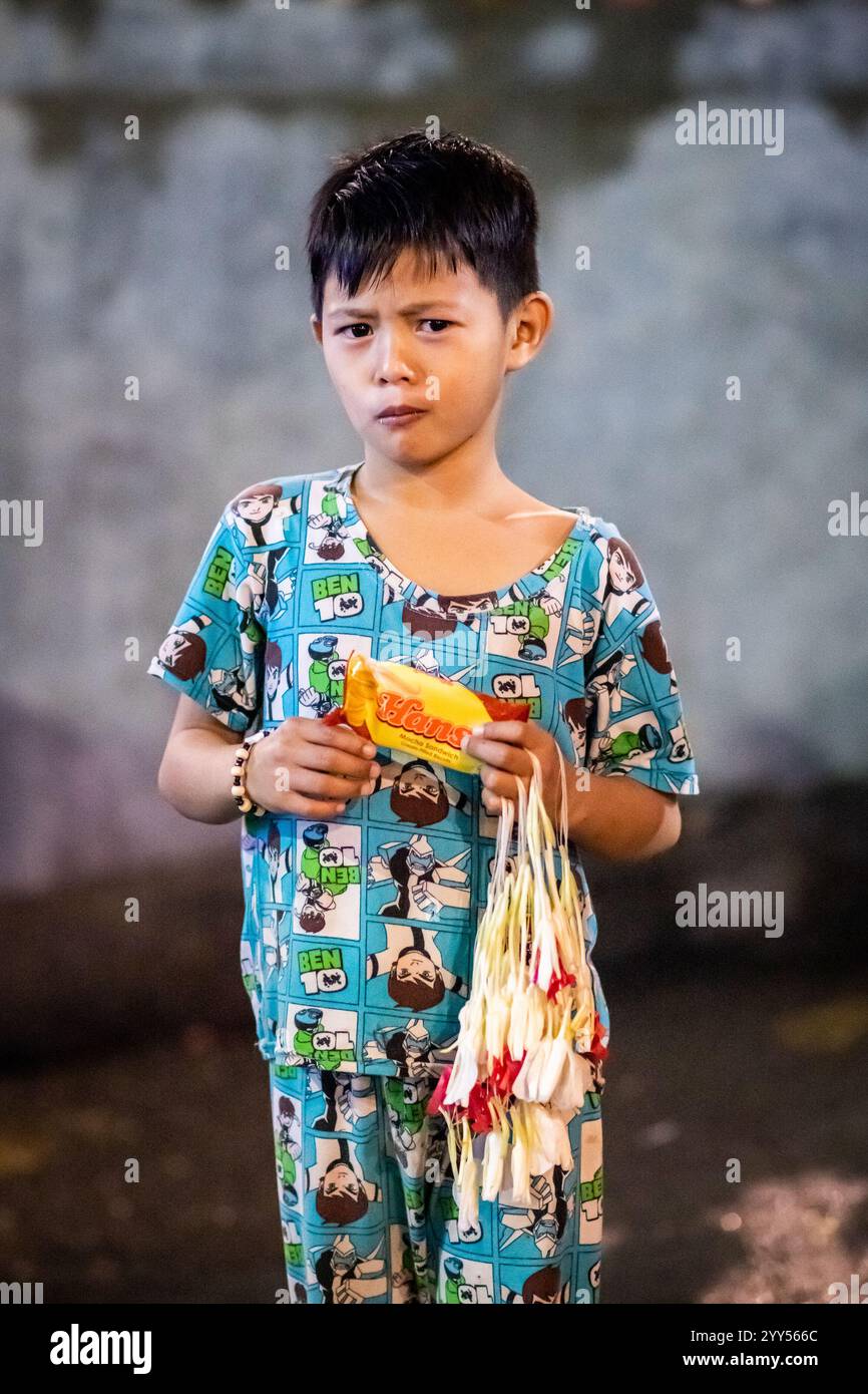 Young filipino boys sell flower garlands to worshippers outside the ...