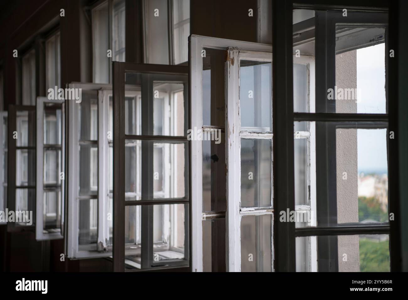 Row of old vintage white open windows in school classroom. Natural lighting trough the window. Closeup window frame. Stock Photo