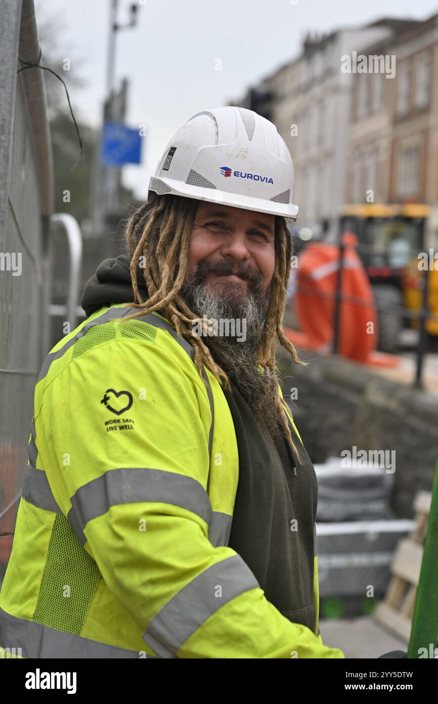 Portrait of bearded smiling construction workman with hard had and yellow safety jacket Stock Photo